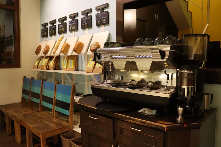 A warmly lit café interior with an espresso machine